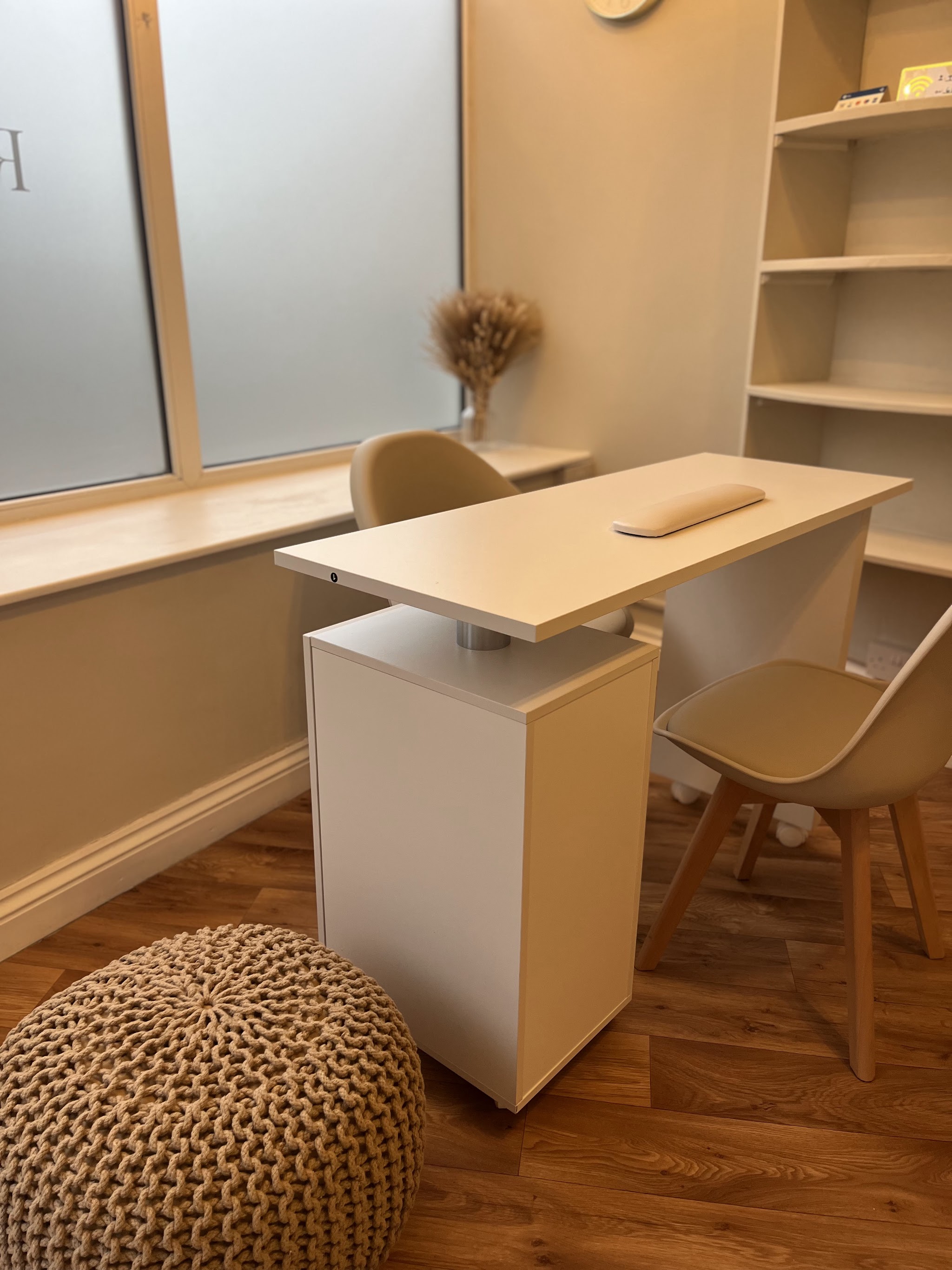 The desk area with shelving and a knitted pouffe