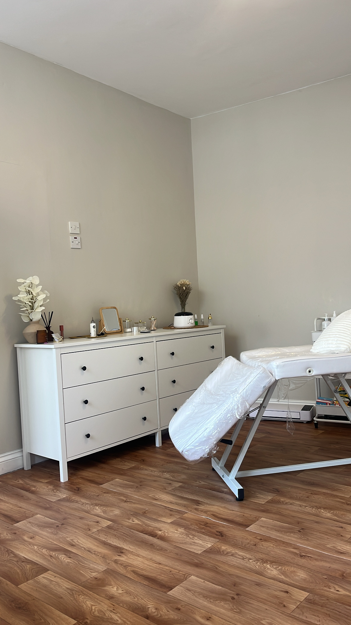 The treatment room with a white couch and chest of drawers