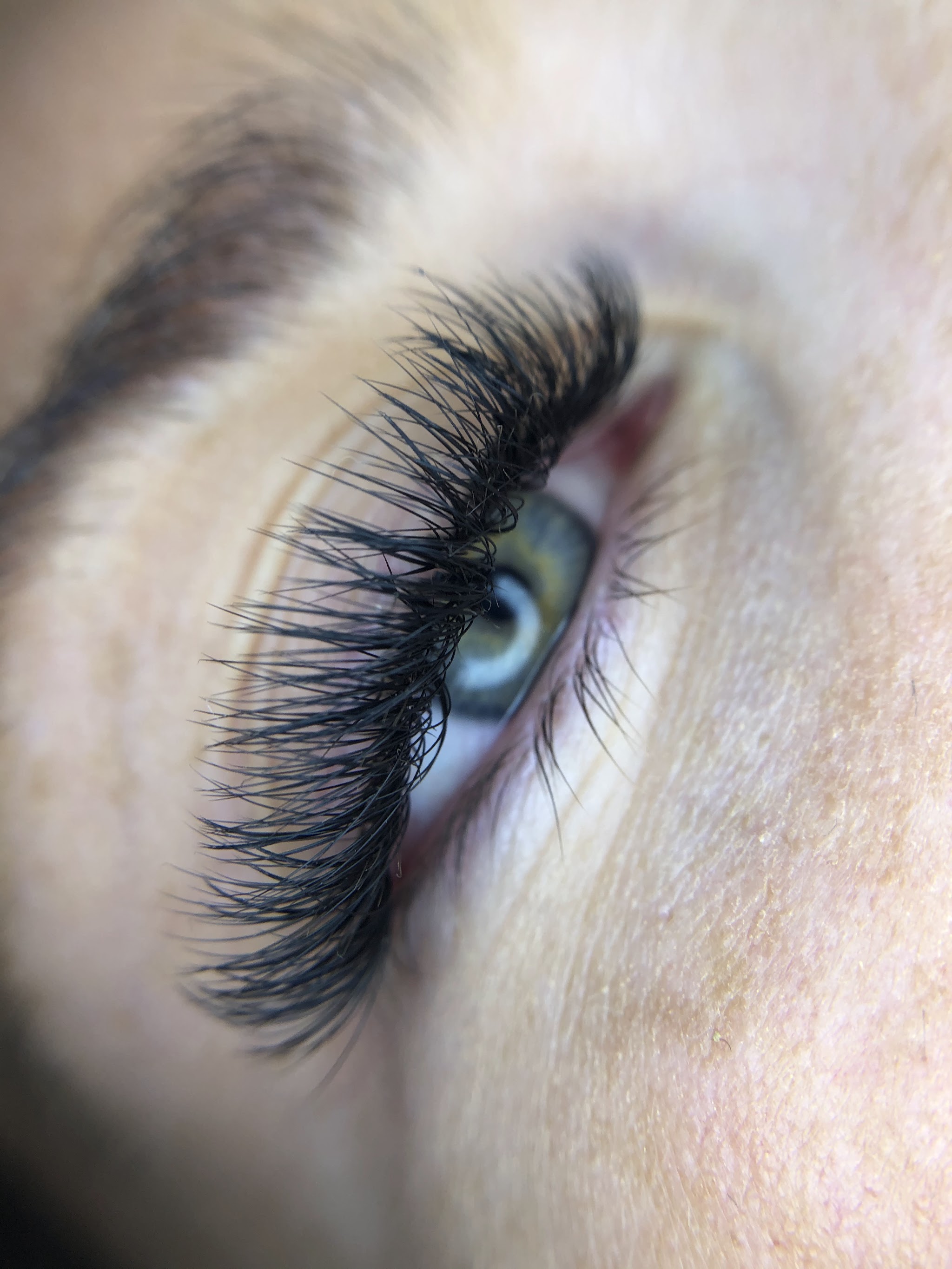 Lash extensions close up on a green eye